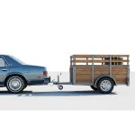 Vintage car towing an old trailer for transporting goods